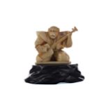 A JAPANESE IVORY CARVING OF A MONKEY MUSICIAN