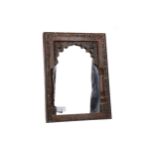 A MOORISH CARVED WOOD FRAMED MIRROR AND A PLATED FLORAL PLAQUE