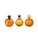 A GROUP OF THREE EARLY 20TH CENTURY AMBER GLASS FIRE GRENADE EXTINGUISHERS