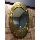 AN ARTS & CRAFTS BRASS AND ENAMEL MARQUISE SHAPED WALL MIRROR