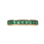 AN EMERALD HALF ETERNITY RING