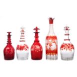 A COLLECTION OF FIVE LATE 19TH CENTURY BOHEMIAN CRANBERRY GLASS DECANTERS, ALONG WITH NINE GLASSES