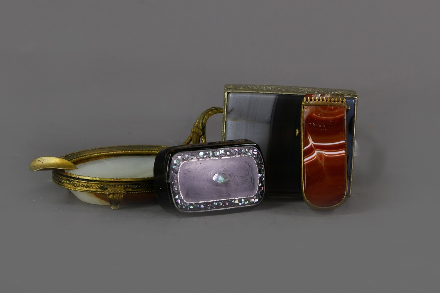 AN EARLY 20TH CENTURY BRASS MOUNTED AGATE ASH DISH, ALONG WITH AN ETUI, TRINKET BOX AND SNUFF BOX