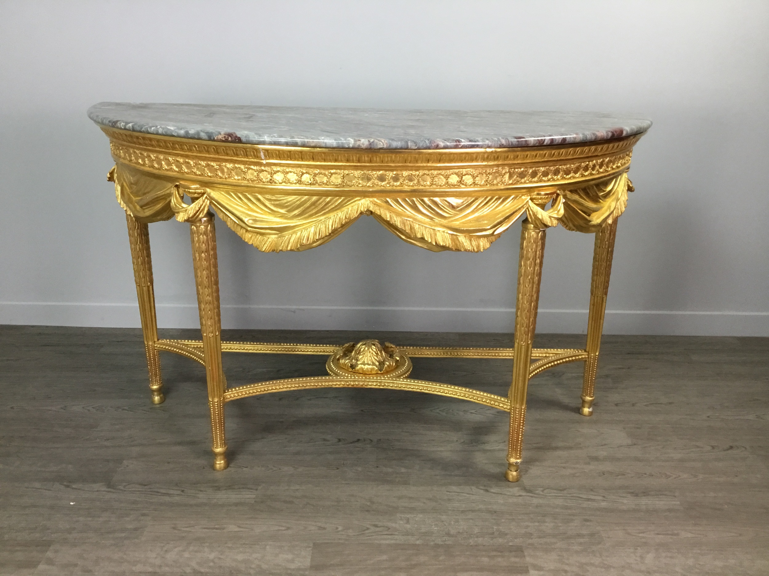 A LATE 19TH CENTURY GILTWOOD DEMI LUNE CONSOLE TABLE OF LOUIS XVI DESIGN