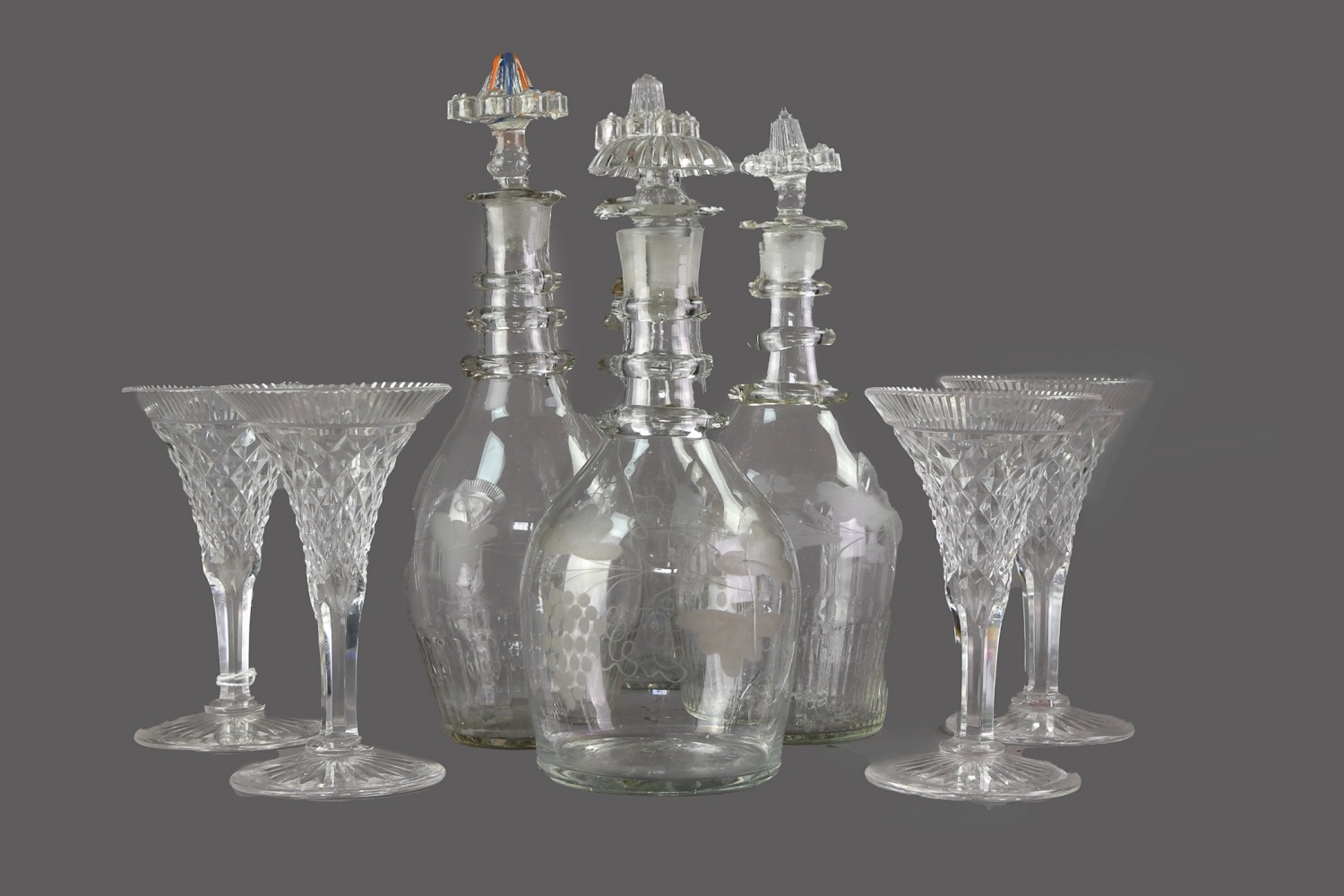 A COLLECTION OF FOUR LATE VICTORIAN GLASS DECANTERS, ALONG WITH FOUR WINE GLASSES