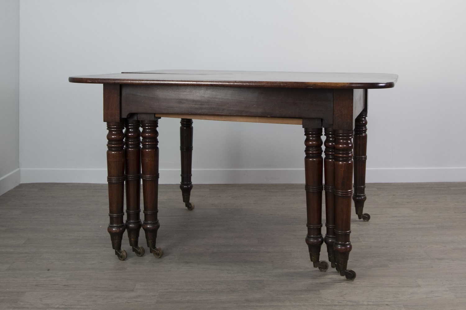 A REGENCY MAHOGANY EXTENDING DINING TABLE