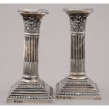 A PAIR OF VICTORIAN DWARF SILVER COLUMNAR CANDLESTICKS WITH STOP FLUTED SHAFT AND CORINTHIAN