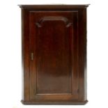 A GEORGE III OAK HANGING CORNER CUPBOARD, LATE 18TH C, FITTED WITH THREE SERPENTINE SHELVES,