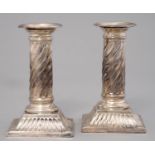 A PAIR OF VICTORIAN SILVER DWARF COLUMNAR CANDLESTICKS, THE SPIRALLY FLUTED SHAFT ON SQUARE FOOT,