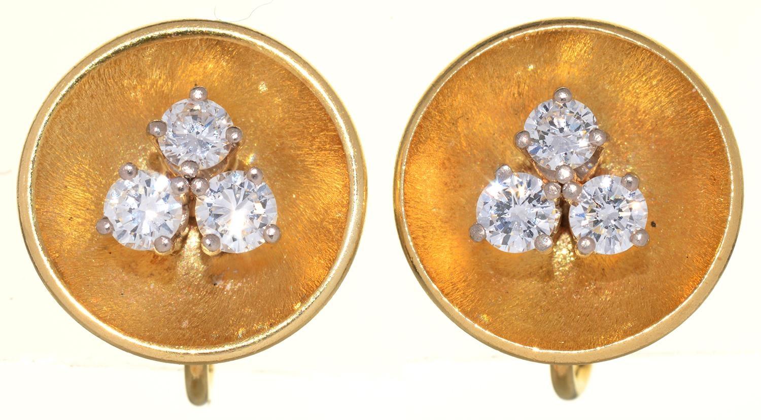 A PAIR OF DIAMOND EARRINGS, C1960, THE THREE ROUND BRILLIANT CUT DIAMONDS BEFORE CONCAVE GOLD