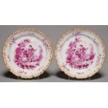 A PAIR OF CONTINENTAL FAIENCE PLATES, C1900. PAINTED IN BRIGHT PUCE CAMAIEU WITH TWO MUSICIANS AND A