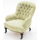 A VICTORIAN NURSING CHAIR, IN BUTTONED PALE GREEN BROCADE, ON EBONISED FEET AND CASTORS, SEAT HEIGHT