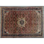 A PERSIAN STYLE MADDER GROUND RUG WITH INDIGO BORDER, 318 X 215CM Slightly faded in one corner but