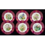 A SET OF SIX CONTINENTAL CLARET GROUND PORCEALIN DESSERT PLATES, C1870, PAINTED WITH COLOURFUL