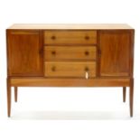 A MID CENTURY WALNUT SIDEBOARD, COTSWOLD SCHOOL STYLE, C1960, FITTED WITH THREE DRAWERS FLANKED BY