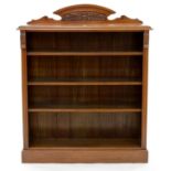 AN EDWARDIAN WALNUT OPEN BOOKCASE, WITH LOW ARCHED, CARVED UPSTAND, HAVING ADJUSTABLE SHELVES
