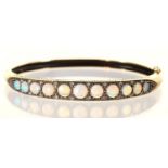 AN OPAL AND WHITE STONE BANGLE IN 9CT GOLD, 58 X 64MM, BIRMINGHAM 2001, 13.5G Good condition