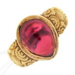 A PEAR  SHAPED RED STONE CABOCHON  RING, ON ASSOCIATED GOLD HOOP WITH CHASED SHOULDERS, UNMARKED,