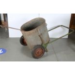 A VINTAGE WATER BOWSER OF OVAL FORM, SITTING ON A GREEN PAINTED TUBULAR METAL FRAME WITH RED
