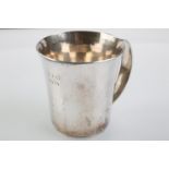 LESLIE DURBIN. AN ARTS AND CRAFTS SILVER CHILD'S MUG, FLARED CYLINDRICAL WITH TAPERING HANDLE,