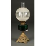 A VICTORIAN GREEN GLASS AND BRASS OIL LAMP,  55CM H, WITH PIERCED GILT IRON FOOT, DRUM SHAPED