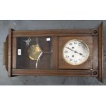 AN OAK WALL CLOCK, C1930, THE DOOR WITH BEVELLED GLASS LIGHTS, SILVERED DIAL, PENDULUM, 68CM H