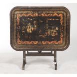 A VICTORIAN BLACK JAPANNED PAPIER MACHE TEA TRAY, MID 19TH C, ADAPTED AS A FOLDING TABLE, ON BLACK