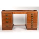 A TEAK VENEERED TWIN PEDESTAL DESK, THREE QUARTER GALLERY, THE TOP INSET WITH A TOOLED LEATHER