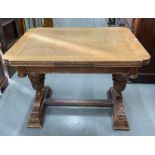 AN OAK DRAW LEAF TABLE, THE ROUND RECTANGULAR TOP ABOVE A SHALLOW FRIEZE AND FOLIATE CARVED