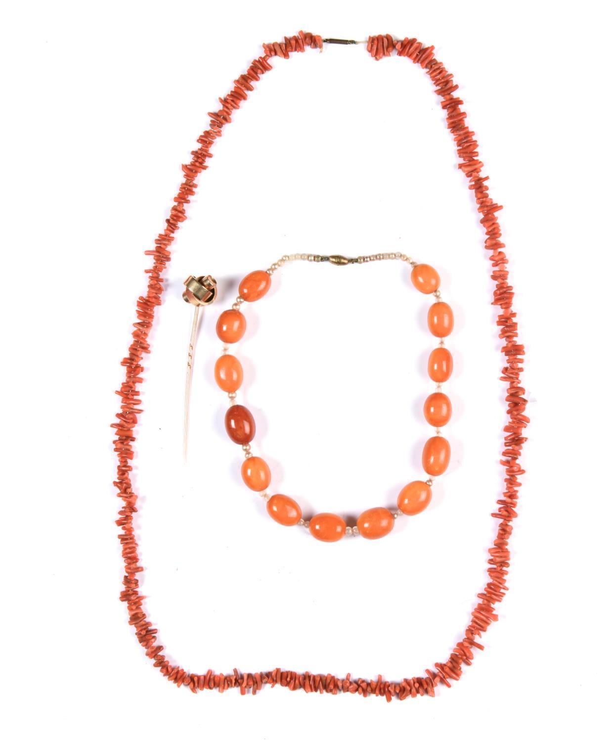 A NECKLACE OF FOURTEEN AMBER BEADS WITH IMITATION PEARL SPACERS, 30.5G, A CORAL TWIG NECKLACE AND