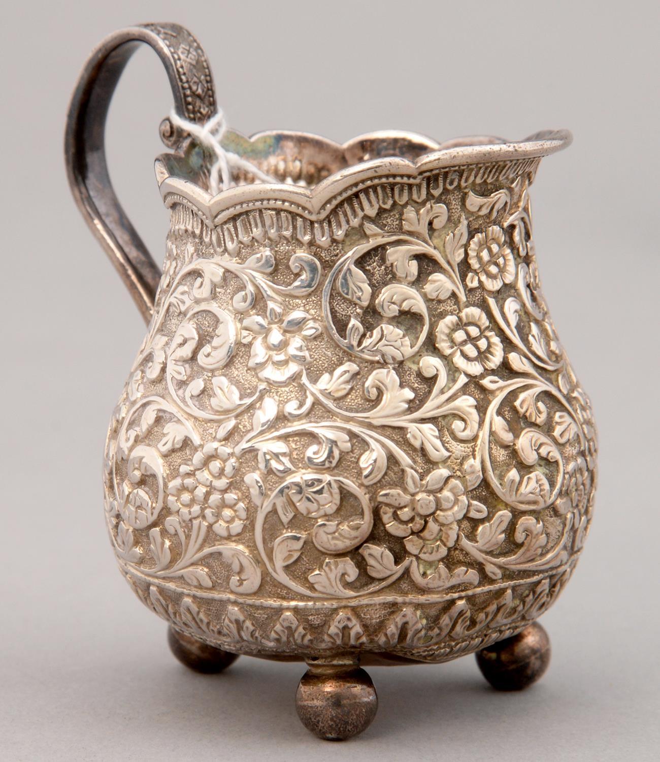 AN INDIAN SILVER REPOUSSE CREAM JUG, KUTCH, LATE 19TH C, ON THREE BALL FEET, 86MM H, 3OZS 8DWTS