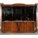 A REPRODUCTION BURR WALNUT VENEERED ART DECO STYLE SERPENTINE FRONTED SIDEBOARD WITH ORNATE BEVELLED