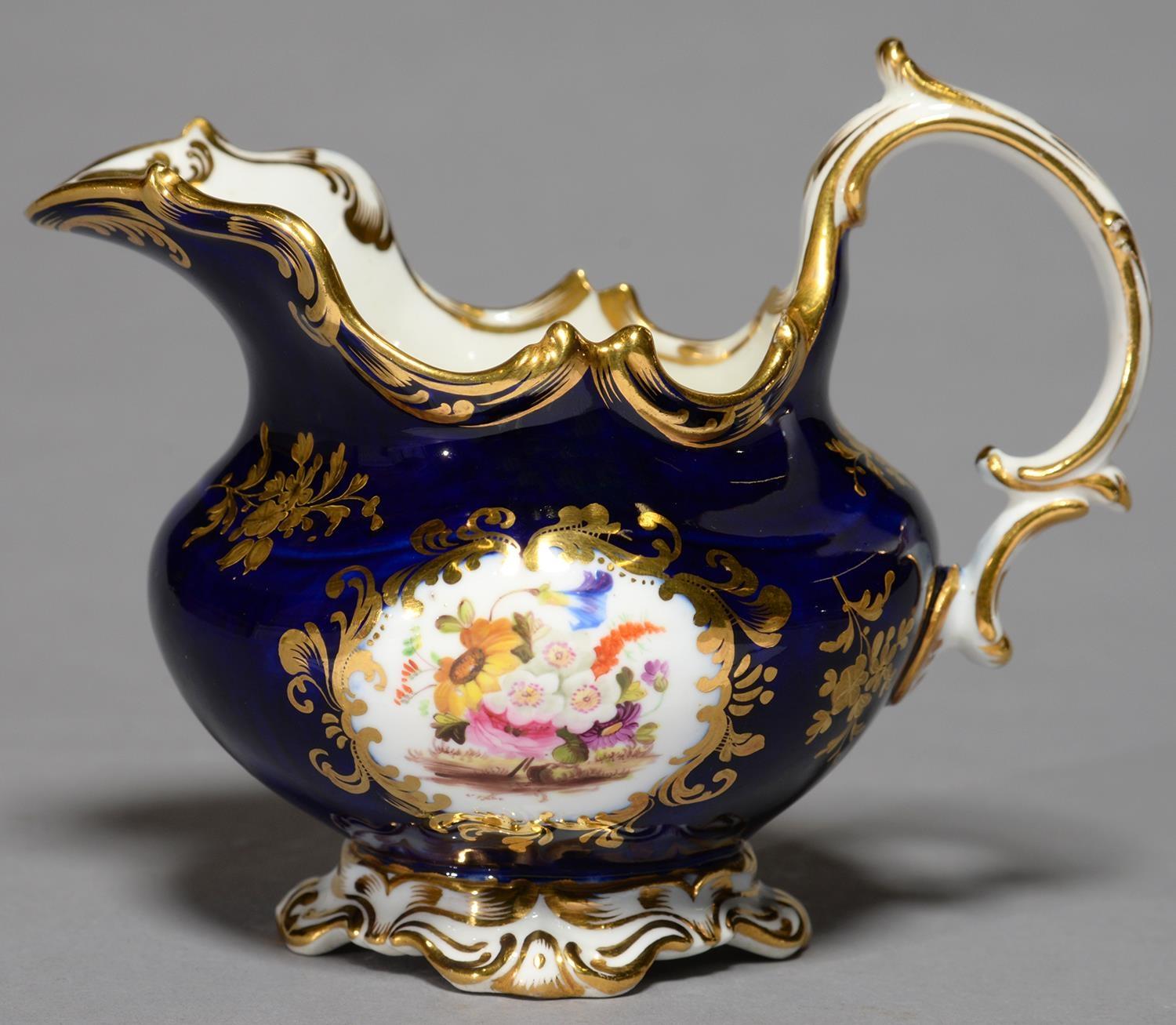 A  COALPORT COBALT GROUND CREAM JUG, C1835, PAINTED TO EITHER SIDE WITH A LOOSE BOUQUET FLANKED BY