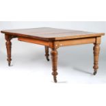 A VICTORIAN OAK EXTENDING DINING TABLE WITH ONE ADDITIONAL LEAF, ON TURNED LEGS AND POTTERY CASTORS,