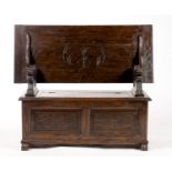 A REPRODUCTION OAK MONK'S BENCH, MID 20TH C, THE FOLIATE AND ROUNDEL CARVED HINGED LID FOLDING TO