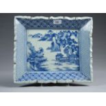 A JAPANESE RECTANGULAR BLUE AND WHITE DISH, EARLY 20TH C, PAINTED WITH A LANDSCAPE IN DIAPER BORDER,