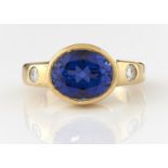 A SYNTHETIC SAPPHIRE RING WITH DIAMOND SHOULDERS, IN 18CT GOLD, CONVENTION MARKED, 11.5G, SIZE L½