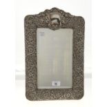 AN EDWARDIAN SILVER DRESSING MIRROR, THE PIECED MOUNT DIE STAMPED WITH FLOWERS AND SCROLLING