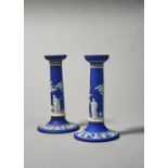 A PAIR OF WEDGWOOD DARK BLUE JASPER DIP CANDLESTICKS, EARLY 20TH C, SPRIGGED WITH APOLLO AND