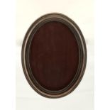 A GEORGE V OVAL SILVER PHOTOGRAPH FRAME, BACKED ON OAK, 21.5CM H, BY T H HAZELWOOD & CO,