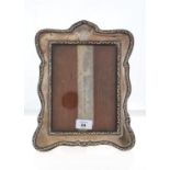 AN EDWARDIAN SILVER PHOTOGRAPH FRAME, THE MOUNT WITH EMBOSSED DOUBLE BORDER,  BACKED ON OAK, 30CM H,