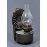 A BRITISH MADE WALL HANGING OIL LAMP, THE BACKPLATE WITH CIRCULAR FLUTED REFLECTOR, THE