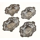 A SET OF FOUR VICTORIAN PIERCED SILVER BONBON DISHES, APPLIED WITH C SCROLLS AND SHELLS, ON