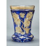 A BOHEMIAN BLUE CASED, ENAMELLED AND GILT GLASS BEAKER (RANFTBECHER), C1850,  DECORATED WITH