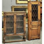 A REPRODUCTION OAK LEAD GLAZED BOOKCASE, THIRD QUARTER 20TH C, THE TOP ABOVE A LUNETTES CARVED