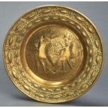 A NUREMBERG BRASS ARMS DISH, 17TH / 18TH C, EMBOSSED TO THE CENTRE WITH WINE MAKERS, 40.5CM DIAM