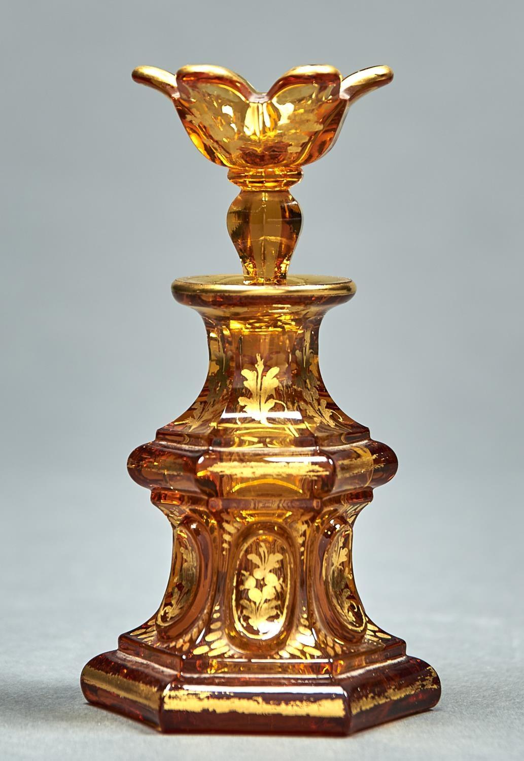 AN AMBER STAINED GLASS SCENT BOTTLE AND STOPPER, MID 19TH C, OF WAISTED HEXAGONAL FORM AND GILT WITH