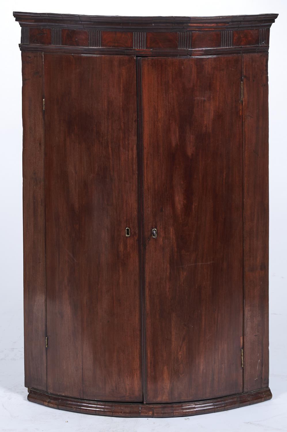 A GEORGE III MAHOGANY HANGING CORNER CUPBOARD, C1780, THE CAVETTO MOULDED CORNICE ABOVE A FLUTED