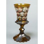 A BOHEMIAN AMBER CASED, RUBY FLASHED ENGRAVED AND ENAMELLED GLASS GOBLET, C1860, THE FLARED BOWL