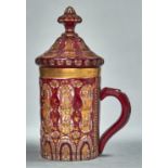 A BOHEMIAN RUBY FLASHED AND ENAMELLED GLASS MUG AND COVER, POSSIBLY MADE FOR THE OTTOMAN MARKET,